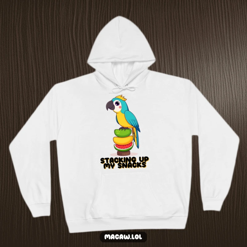 Funny hoodie featuring a playful macaw bird performing a daring balancing act with a towering stack of exotic fruits.